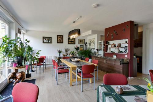 eine Küche und ein Esszimmer mit roten Stühlen und einem Tisch in der Unterkunft Huis van Steen in Lelystad