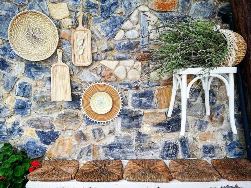 a stone wall with hats and plates on a table at Nafsika Sea View Apartments in Kerveli