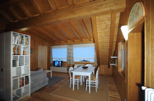 a dining room and living room with a table and chairs at Albergo Diffuso Ravascletto in Ravascletto