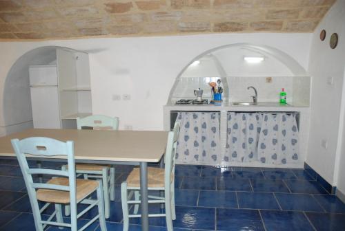 a kitchen with a table and chairs and a sink at B&B Dimora San Vincenzo in Gallipoli