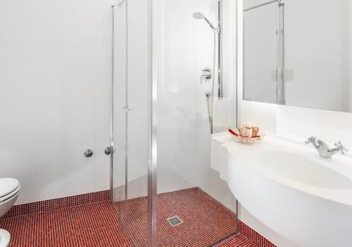 a bathroom with a shower and a sink and a toilet at Hotel Milton Rimini in Rimini