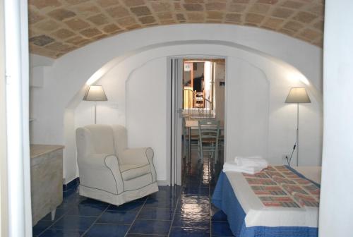 a hotel room with a bed and a chair at B&B Dimora San Vincenzo in Gallipoli
