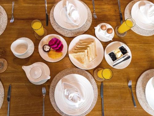 un tavolo di legno con piatti di cibo sopra di Mannao Estate by Villa Finder a Kerobokan