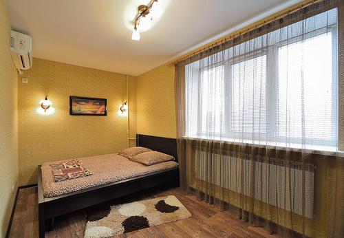 a bedroom with a bed and a large window at Квартира на пр. Яворницкого in Dnipro