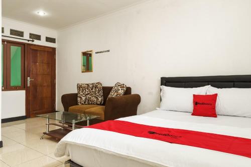 a bedroom with a bed and a chair and a table at RedDoorz @ Cibogo Puncak Bogor 2 in Bogor