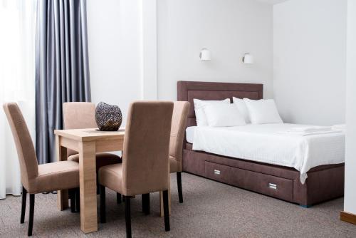 sypialnia z łóżkiem, stołem i krzesłami w obiekcie IPN APARTMENTs w mieście Podgorica