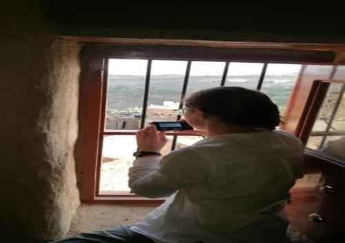 a woman taking a picture of a window at Hissen Al-Misfah in Misfāh