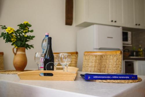 a bottle of wine and glasses on a kitchen counter at Apartman Őri in Bük