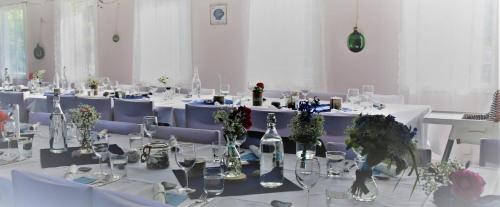 a large room with white tables and blue chairs at Marsbäcken Hostel in Västervik
