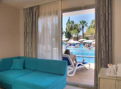 a living room with a couch and a pool at Ephesia Holiday Beach Club in Kusadası