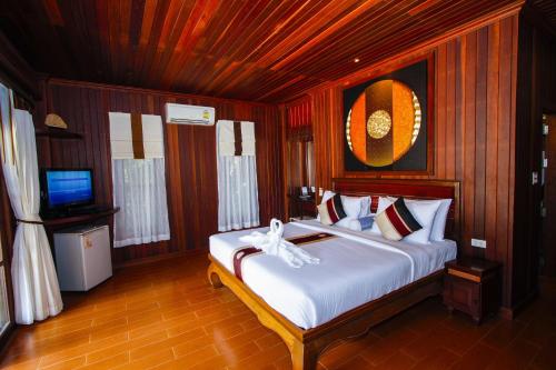 a bedroom with a bed and a tv in it at Baan Grood Arcadia Resort & Spa in Ban Krut