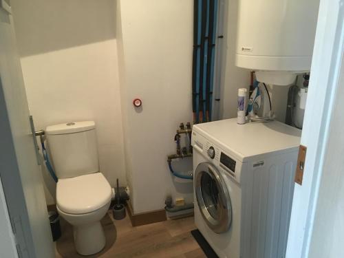 a bathroom with a toilet and a washing machine at Belapparthotel Arras in Arras