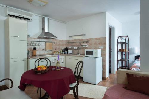 a small kitchen with a table and a room with a couch at Gréta Apartman in Hajdúszoboszló