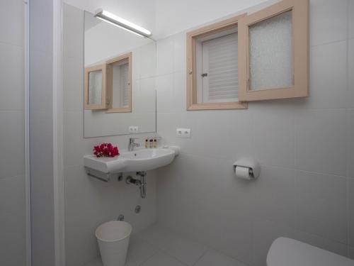 a white bathroom with a sink and a toilet at Hostal Mayans in Es Pujols