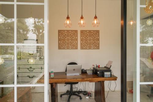 an office with a desk with a laptop computer on it at RedDoorz Plus near Exit Toll Puncak 2 in Bogor