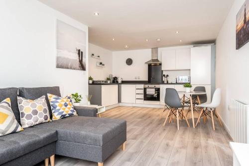 a living room with a couch and a kitchen at Host & Stay - Oldham Place in Liverpool