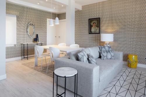 - un salon avec un canapé gris et une table dans l'établissement Sunset by FeelFree Rentals, à Saint-Sébastien