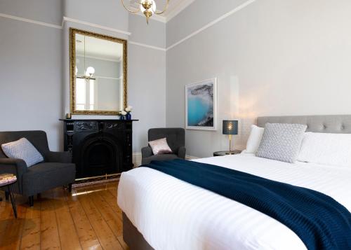1 dormitorio con 1 cama grande y espejo en House at No. 10, en Ballarat