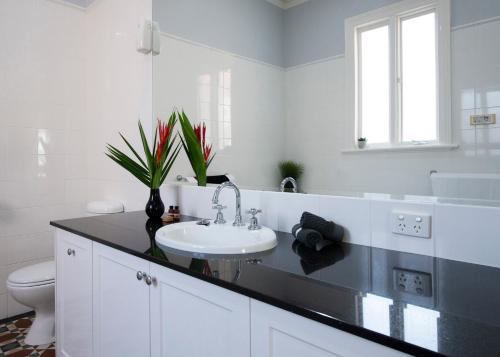 a white bathroom with a sink and a toilet at House at No. 10 in Ballarat