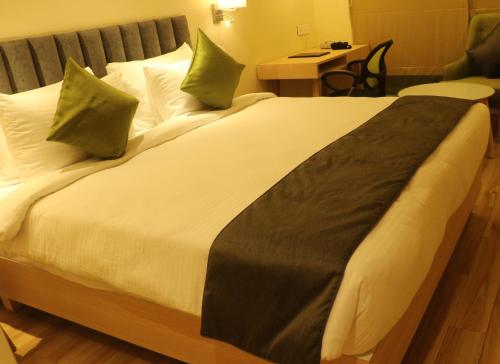 a large bed in a hotel room at Regenta Central Harsha Vapi in Vapi