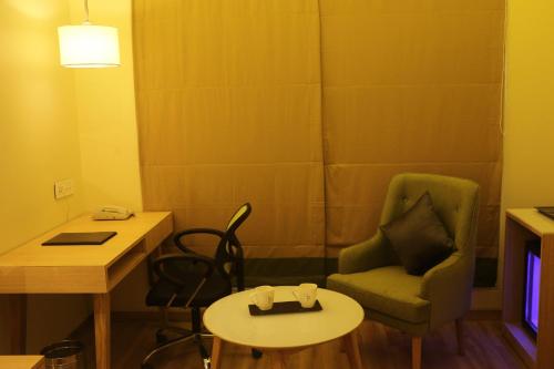 a small room with a table and a chair and a table and a tableablish at Regenta Central Harsha Vapi in Vapi