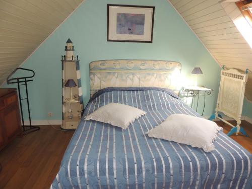 a bedroom with a bed with two pillows on it at Chez Jocelyne Lhermite in Bangor