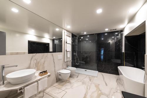 a bathroom with two sinks and a toilet and a tub at Locanda Leon Bianco on the Grand Canal in Venice