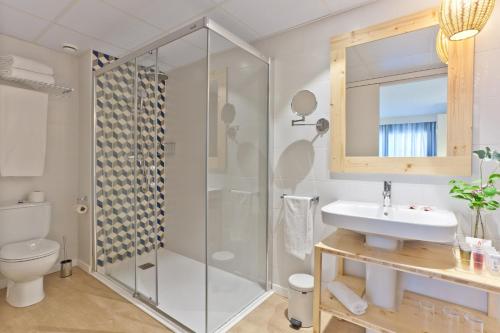 uma casa de banho com um chuveiro e um lavatório. em 30º Hotels - Hotel Pineda Splash em Pineda de Mar