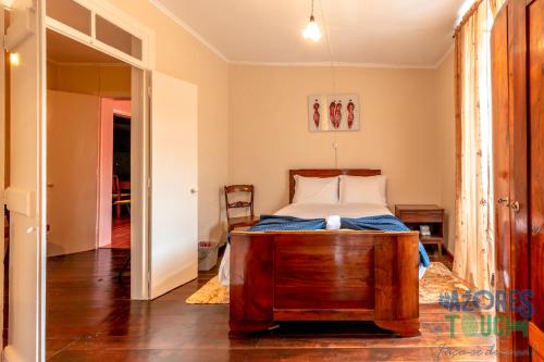 ein Schlafzimmer mit einem Bett mit einem Holzrahmen in der Unterkunft House Rebelo in Terra Chã