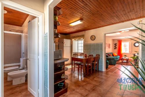 a kitchen and living room with a table and a couch at House Rebelo in Terra Chã