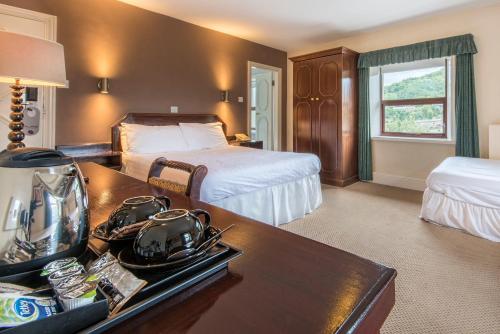 a hotel room with a bed and a desk with a table sidx sidx at The Imperial Crown Hotel in Halifax