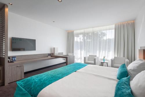 Habitación de hotel con cama y TV en Van der Valk Hotel Vianen - Utrecht, en Vianen