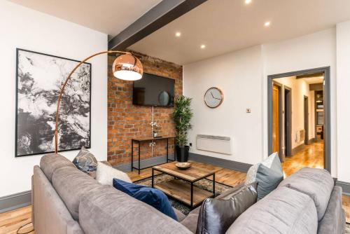 a living room with a couch and a brick wall at Host & Stay - Bands Warehouse I in Liverpool