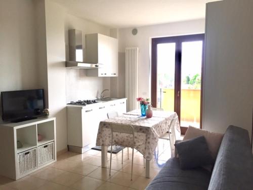 a living room with a table and a kitchen at Appartamento Mare Nardo in Porto SantʼElpidio
