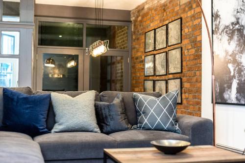 a living room with a couch and a brick wall at Host & Stay - Bands Warehouse I in Liverpool