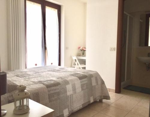 1 dormitorio con 1 cama con manta y mesa en Appartamento Mare Nardo, en Porto SantʼElpidio