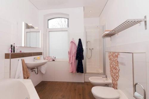 uma casa de banho branca com um lavatório e um WC em Private Apartment em Hanôver