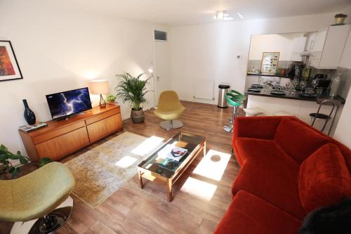a living room with a red couch and a table at 3beds/2baths in Oxford Circus in London