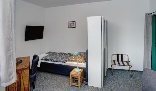 a bedroom with a bed and a desk and a chair at Pension Pegast in České Budějovice