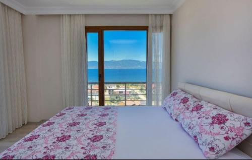 a bedroom with a bed with a view of the ocean at Erpey Ferah Apart Otel in Balıkesir