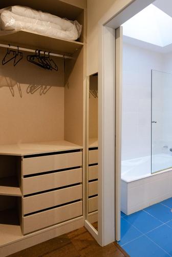 a walk in closet with a tub and a walk in shower at Porto Gaia City House by MP in Vila Nova de Gaia