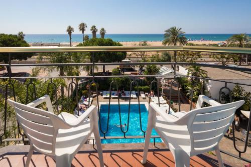 einen Balkon mit 2 Stühlen und einem Pool in der Unterkunft htop Planamar #htopEnjoy in Malgrat de Mar