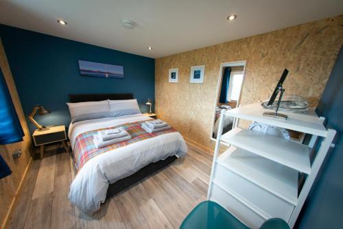 Struan的住宿－Lochanside，一间卧室设有一张床和蓝色的墙壁