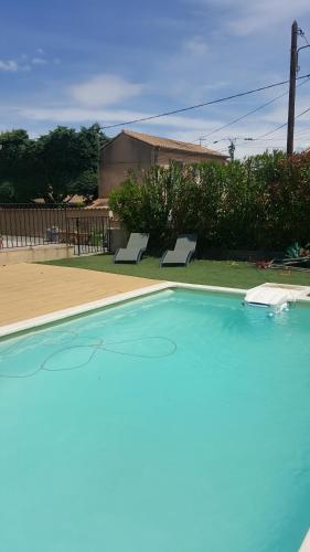 une piscine vide avec deux bancs dans une cour dans l'établissement Le Clos de Carinette, à Châteauneuf-du-Pape