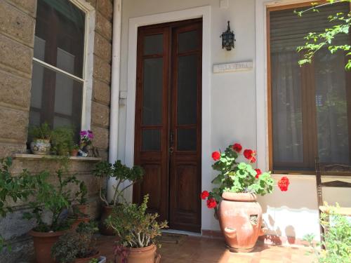 a front door of a house with pots of flowers at Villa Serra B&B iun E6769 in Oristano