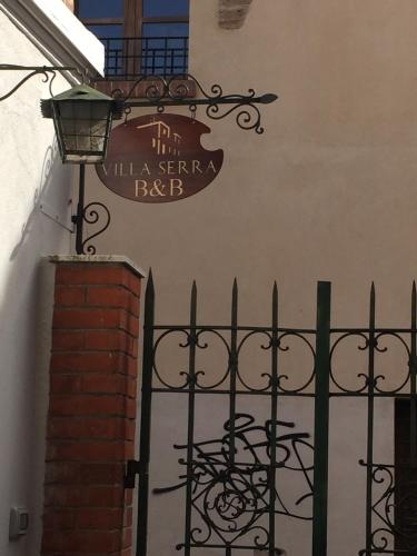 a sign on the side of a building with a iron fence at Villa Serra B&B iun E6769 in Oristano