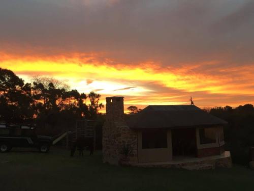 a house with a horse and a sunset in the background at Natures Gem of Mosselbay in Mossel Bay