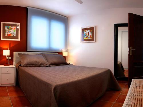 Schlafzimmer mit einem Bett und einem großen Fenster in der Unterkunft Apartamento La Seo in Barbastro