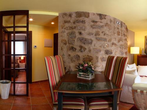 uma sala de estar com uma mesa e uma parede de pedra em Apartamento La Seo em Barbastro