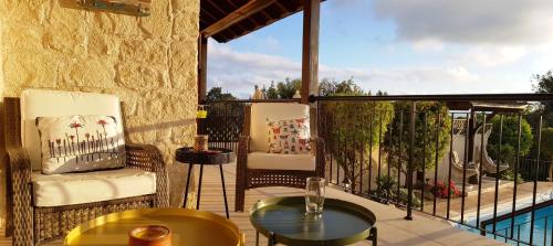 a patio with two chairs and a table on a balcony at Ithaki House in Lyso
